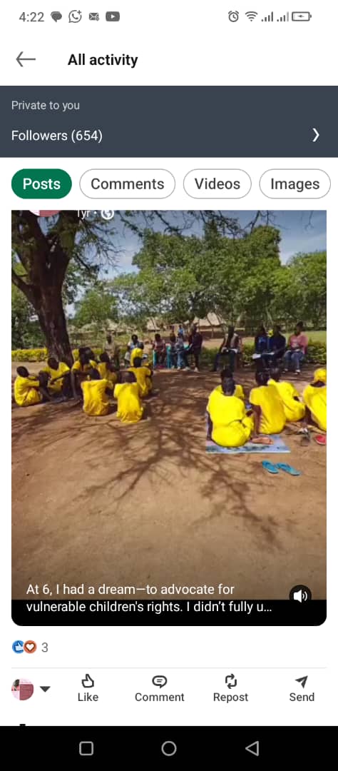 A community group seated in a circle beneath a tree.