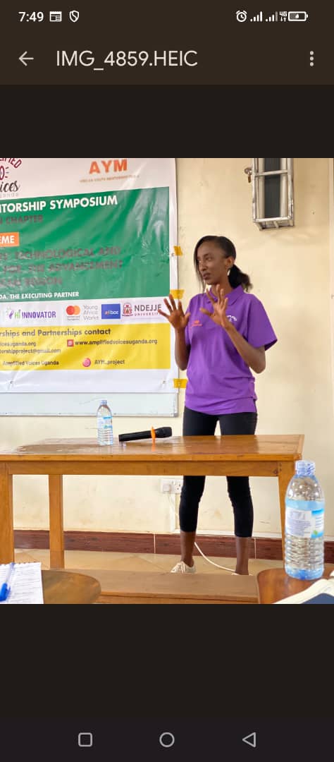 A presenter in a purple shirt speaking at a mentorship session.
